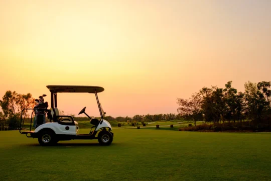Golf cart on a golf course at sunset