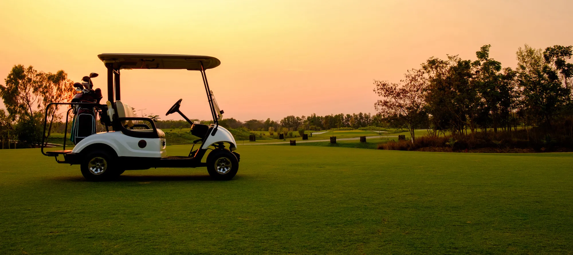 Golf cart on a golf course at sunset